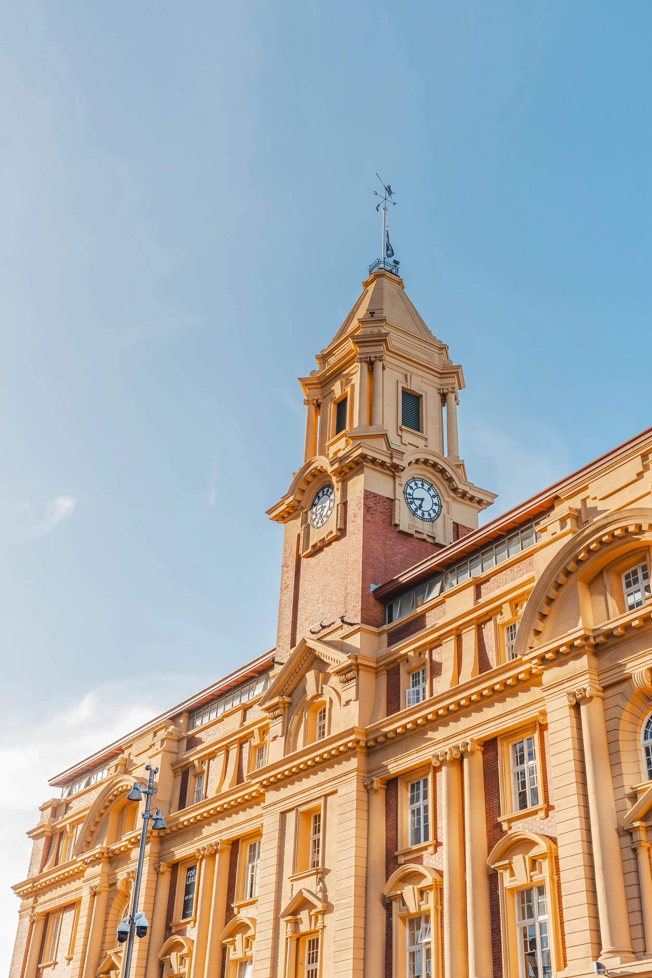 Clock tower of the Auckland Ferry Building against a clear blue sky