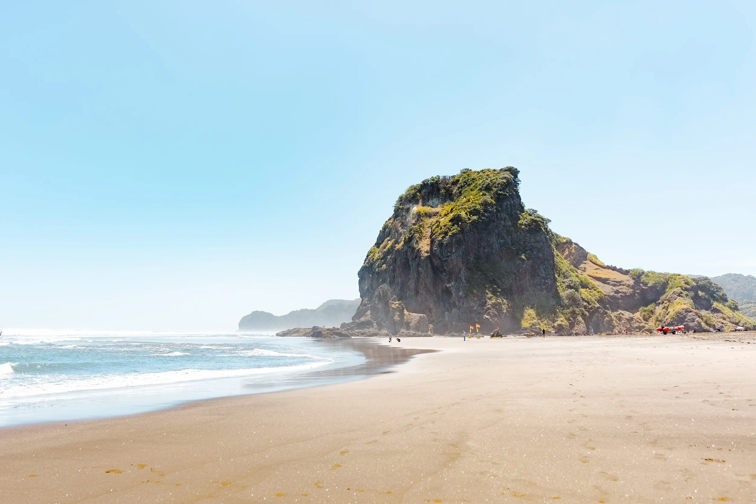Lion Rock rising above the black-sand beach at Piha, New Zealand