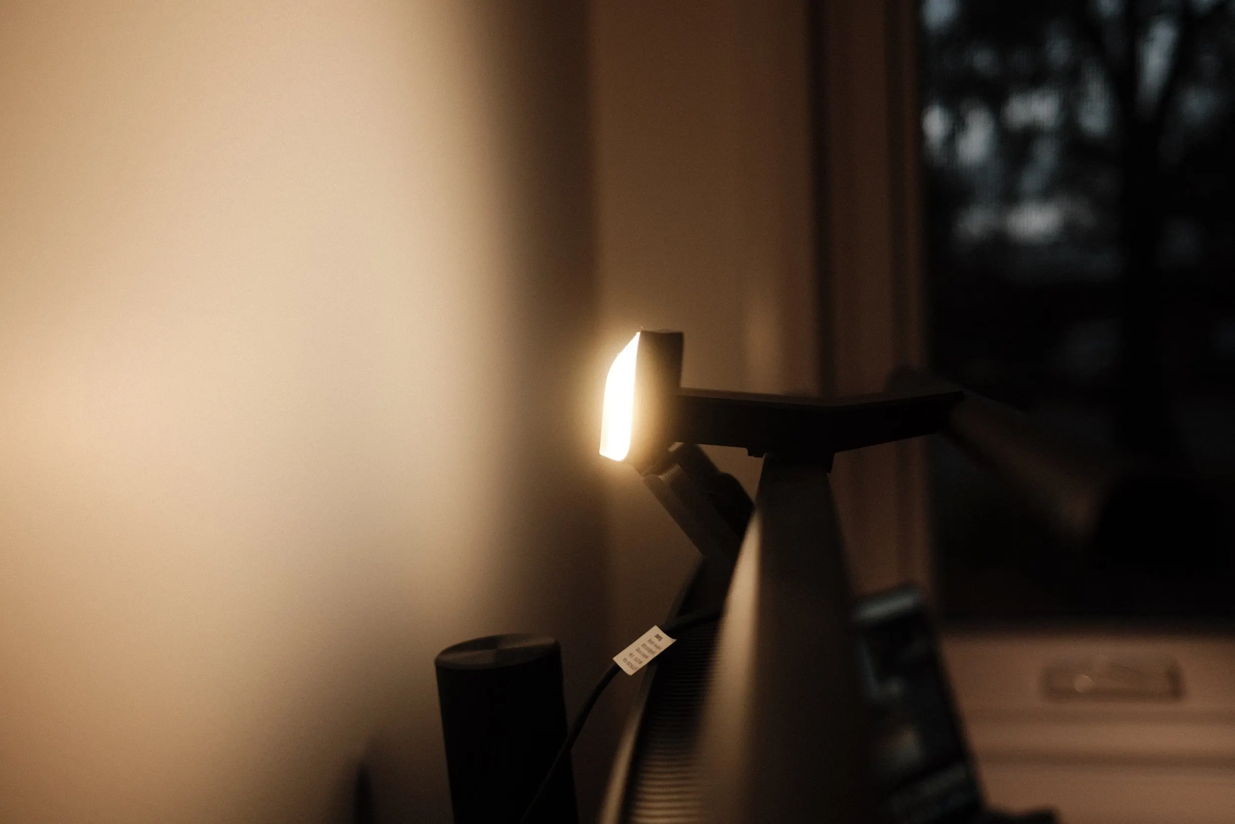BenQ ScreenBar Halo 2 casting warm light over a monitor in a dark room