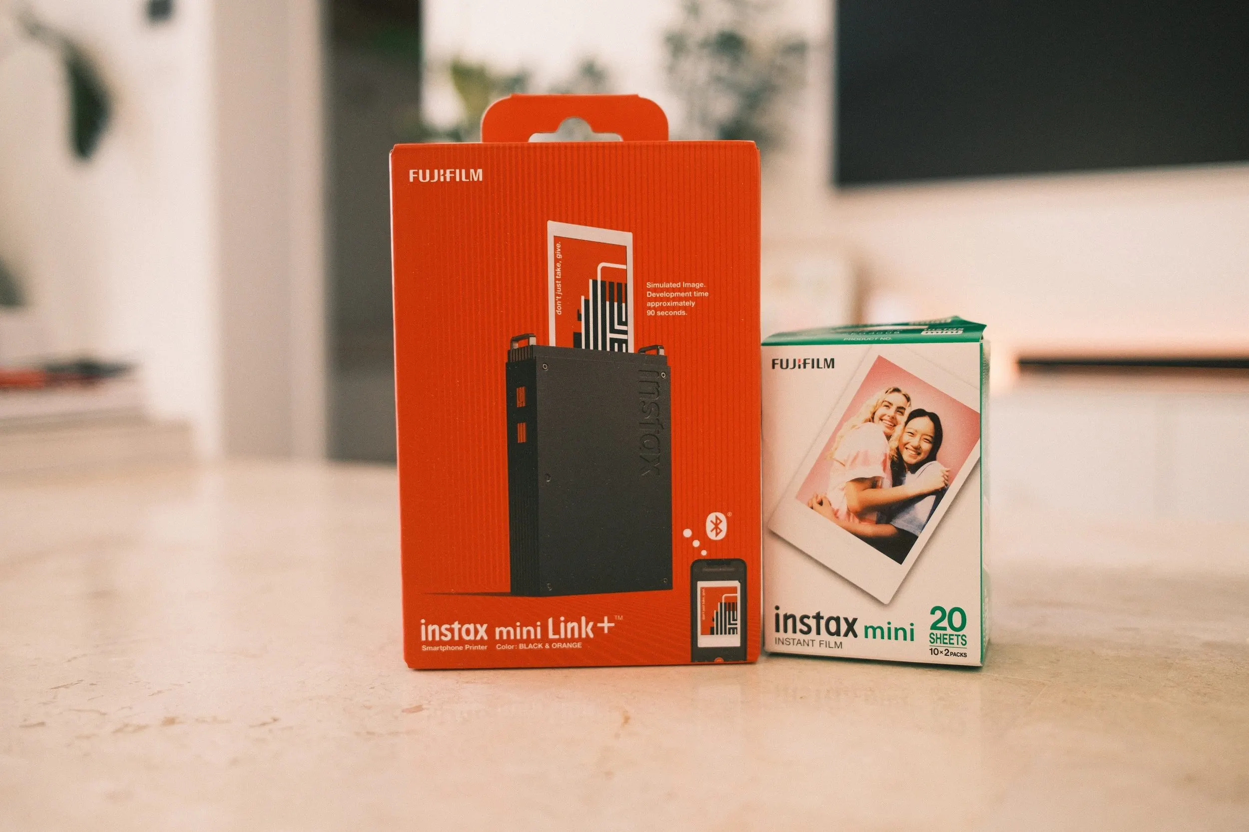 Fujifilm Instax Mini Link+ printer box beside a pack of Instax Mini film