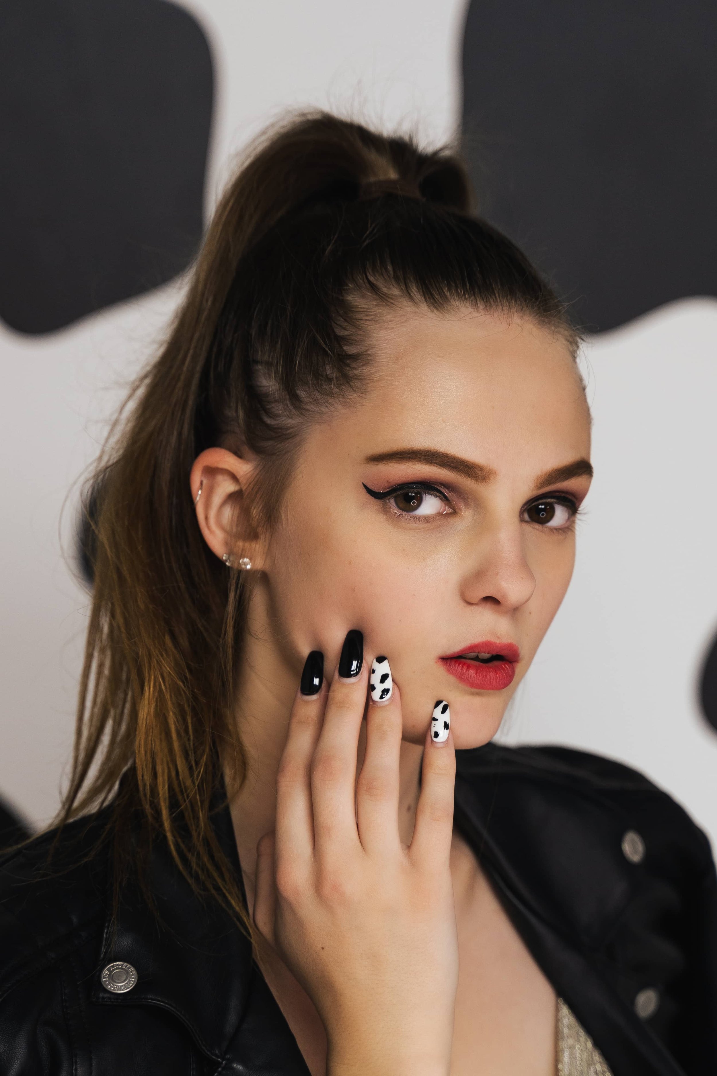 Woman with a high ponytail showing black and white patterned nails