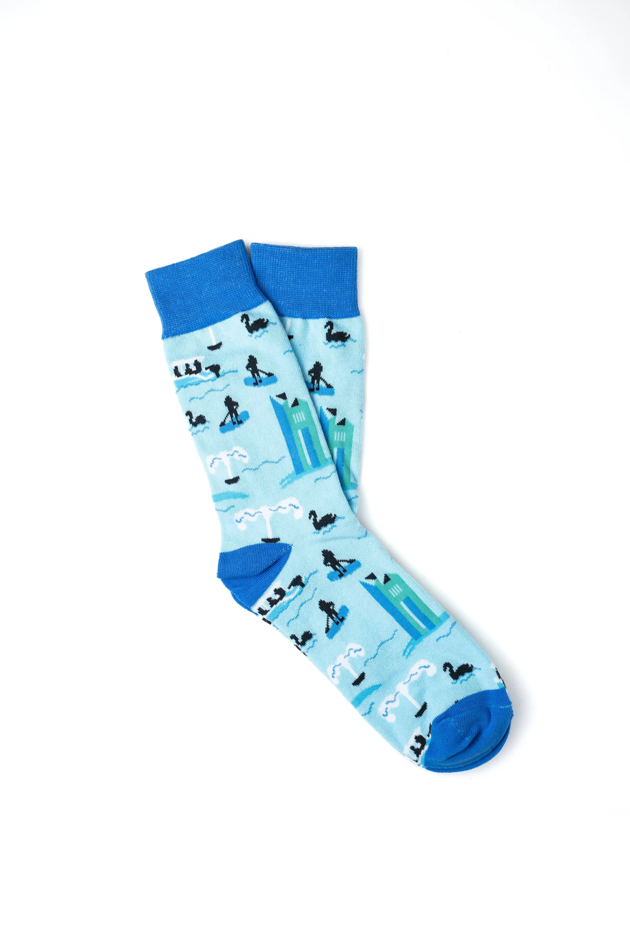 Light blue socks with a beach scene pattern, including sailboats, sea creatures, and a lighthouse, on a white background.