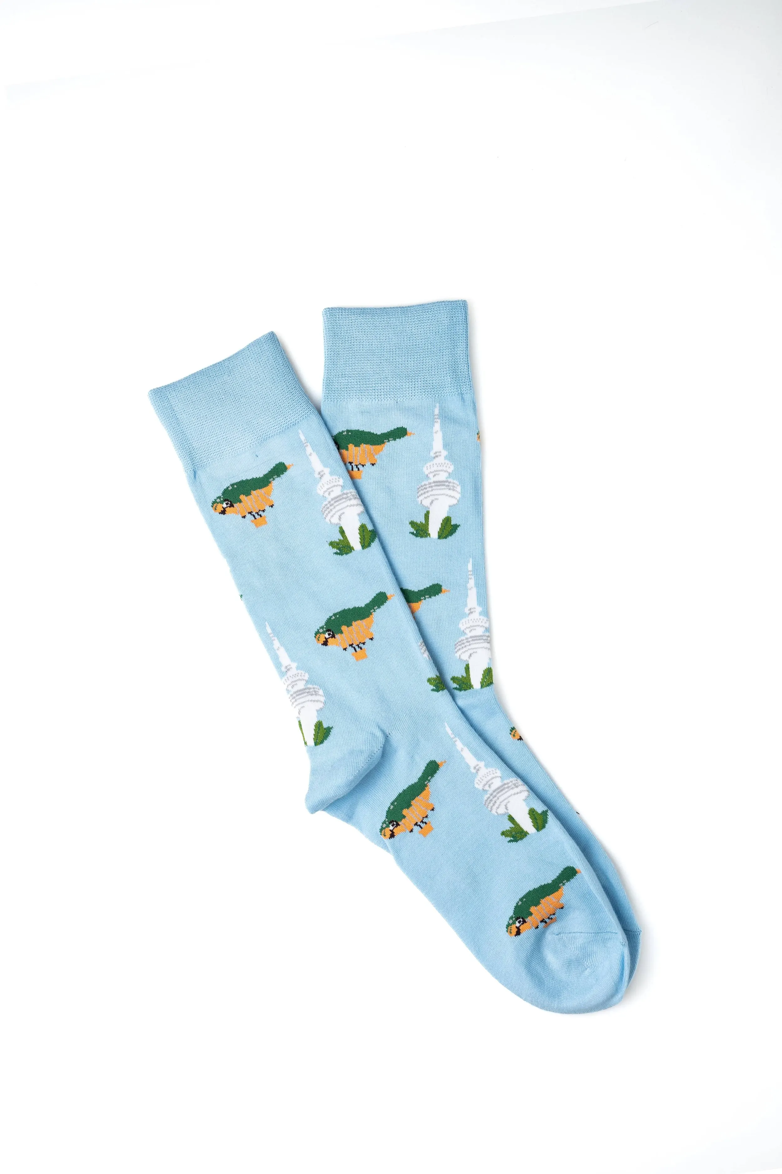 Light blue socks with a pattern of crocodiles and white towers on a white background.