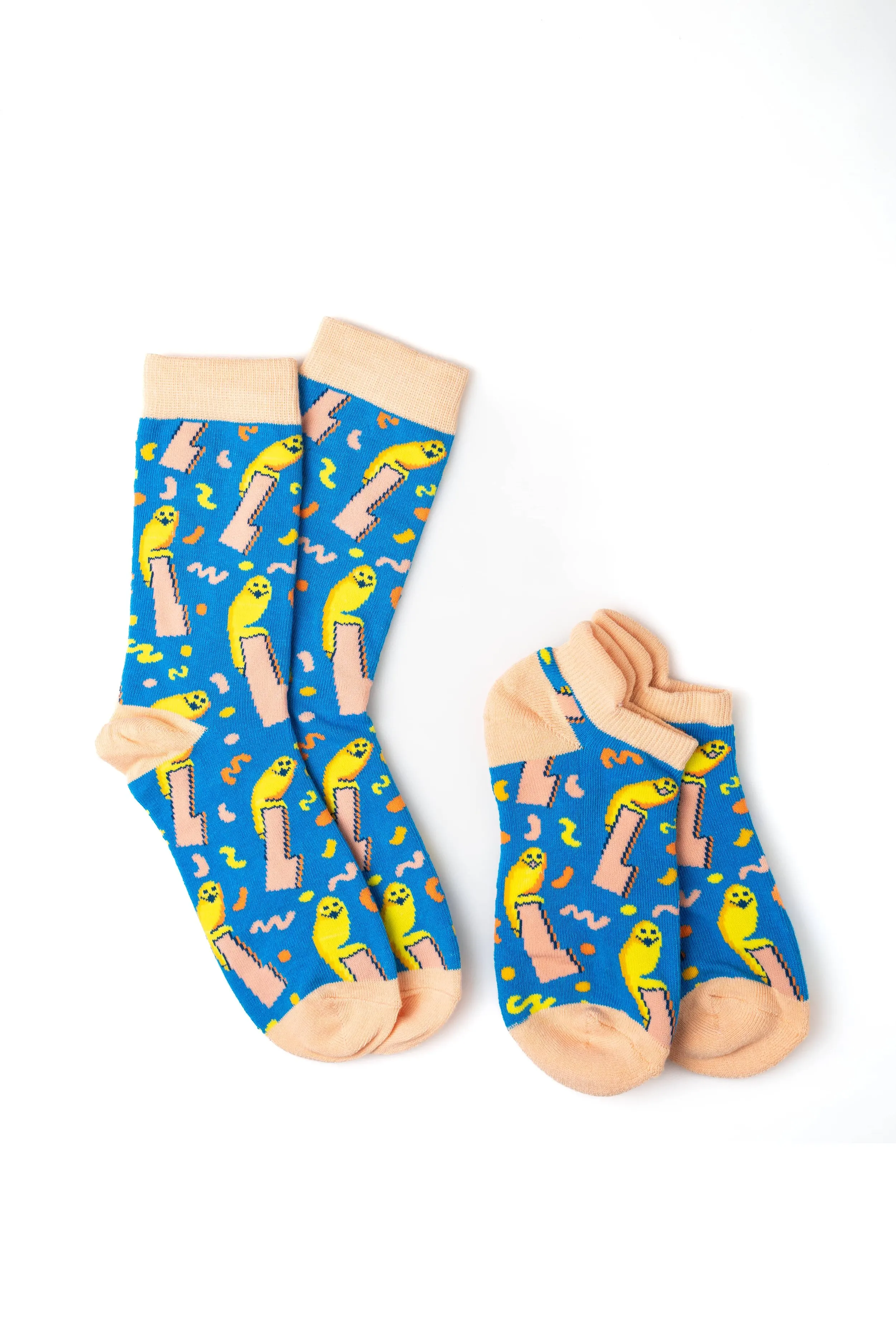 Pair of colorful socks with a playful design featuring yellow and pink cartoon-like bodies and abstract shapes on a blue background.