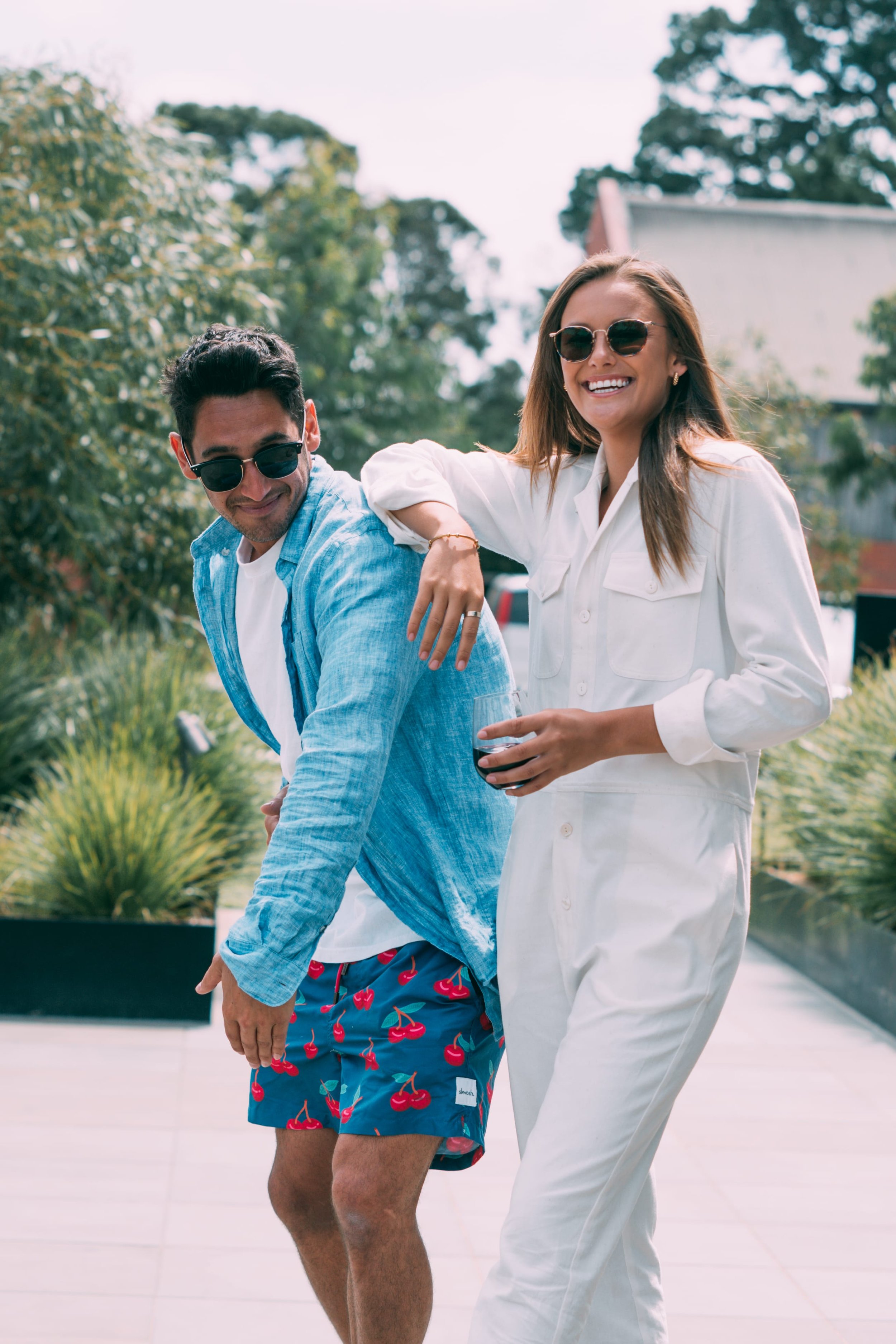 Two guests laughing by a pool at an outdoor event