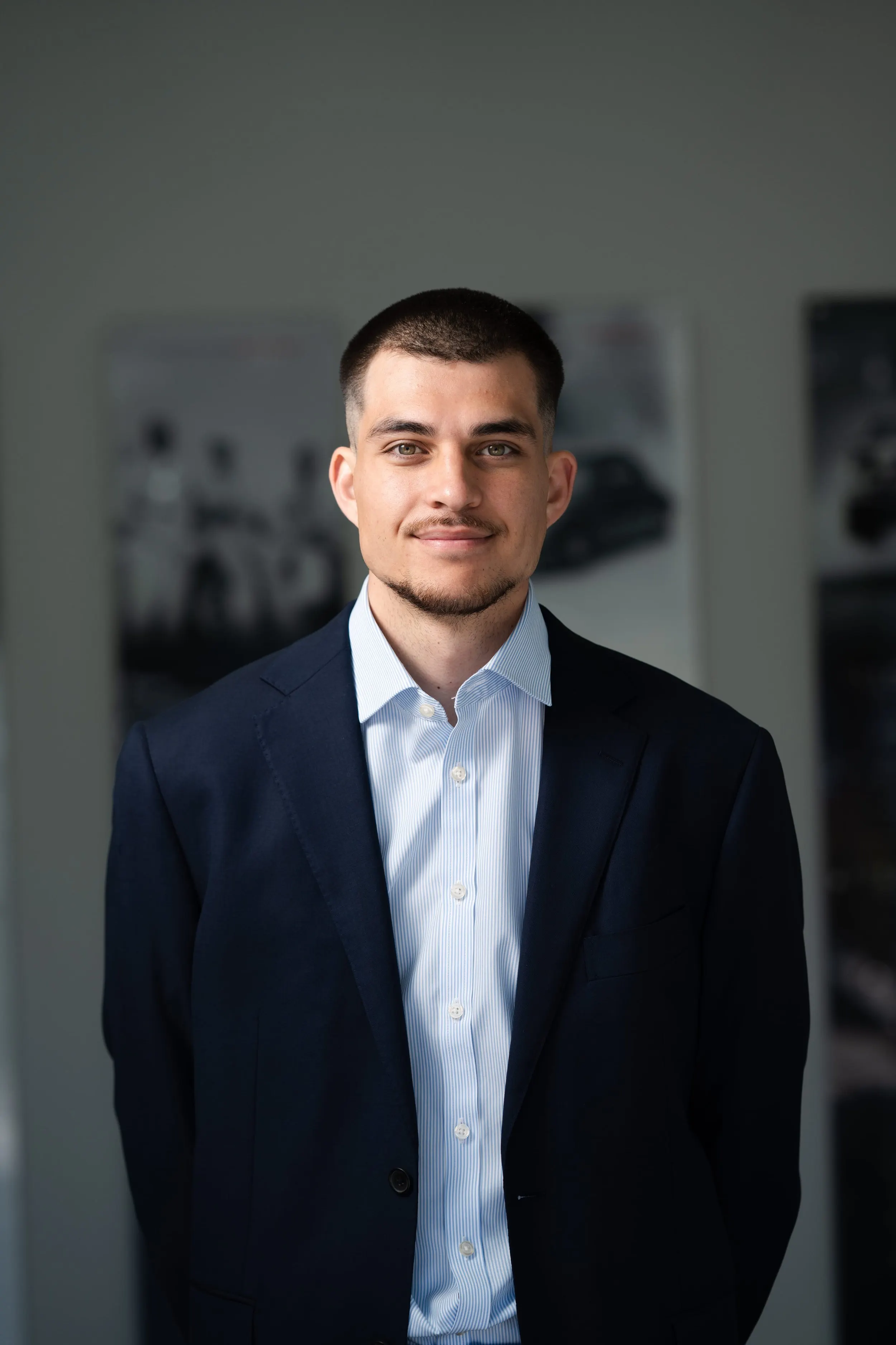 Man in a navy suit jacket and open-collar shirt